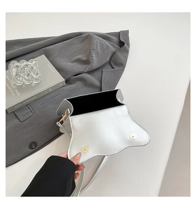 Detailed interior of silver sequin bag featuring magnetic buckles and black fabric lining
