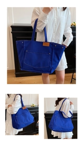Détail du sac cabas en toile bleue avec poche extérieure et écusson en cuir marron