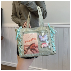 Detail of light green tote bag with clear PVC window and blue ribbon lace-up design