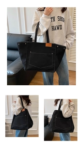 Détail du cabas en toile noire avec surpiqûres contrastées et poche à rivets métalliques