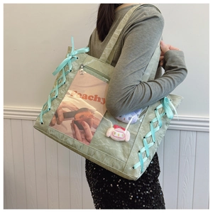 Detail of light green tote bag featuring pleated texture and clear display window