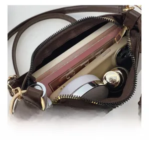 Detail view of the brown saddle bag interior showing storage for phone and makeup