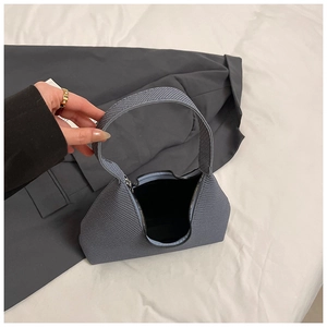 Détail de la texture tissée gris-bleu et du zip en métal sur ce sac à main chic