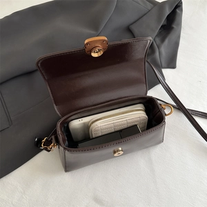 Deep brown square crossbody bag showing internal capacity with phone and wallet