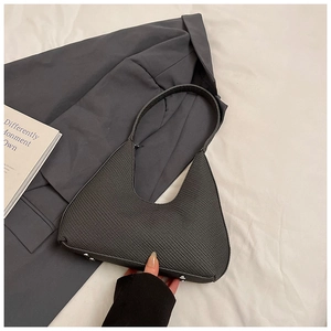 Vue détaillée du sac hobo croissant tissé avec pieds en métal argenté sur tissu blanc