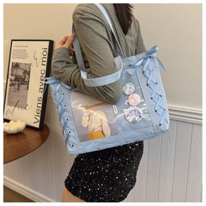 Detail of light blue ita bag showing transparent PVC window with ribbon lace-up sides