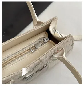 Detail of the smooth metal zipper closure and floral jacquard texture on the straw bag