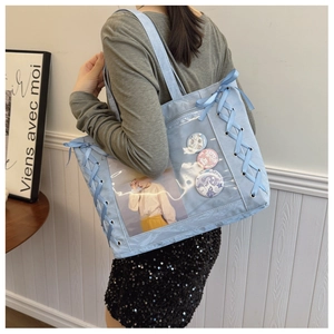 Close-up of light blue ita bag with transparent PVC window and side ribbon bow details