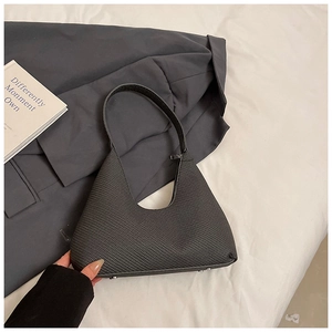 Gros plan des clous de protection argentés sur un sac hobo noir en forme de croissant