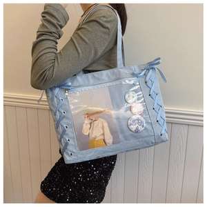 Macro shot of light blue ita bag featuring transparent window and ribbon bow details