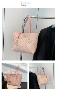 Detailed view of pink tote bag with M monogram texture and gold round charm