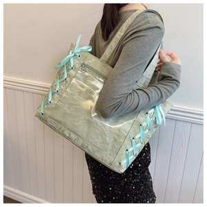 Detail of mint green tote bag with side ribbons and clear window for doll display