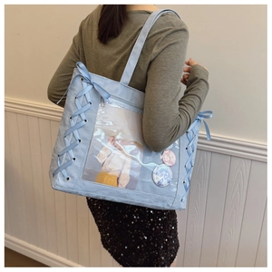 Detail of light blue ita bag showing ribbon lacing and transparent PVC display window