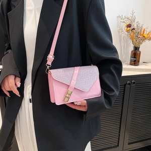 Detail of pink sequin crossbody bag with gold buckle on a stylish suit outfit