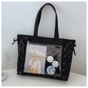 Detail of black ita tote bag with clear PVC pocket, ribbon bows and decorative badges