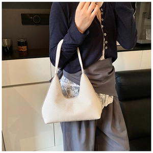 Détail du sac hobo avec texture tissée et design en forme de croissant de couleur crème