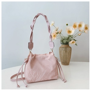 Close-up of pleated texture bucket bag with braided shoulder strap and side drawstring