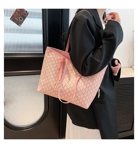 Detail of pink tote bag showing M-letter jacquard pattern and golden metallic charm