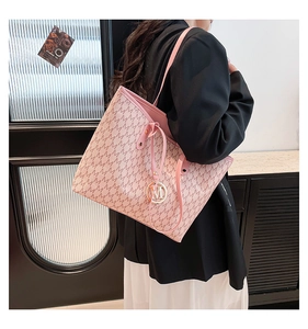 Detail of pink monogram tote bag featuring M-pattern and gold metal letter charm