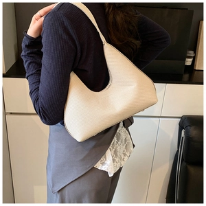 Détail du sac hobo blanc cassé montrant la texture gaufrée et le porté épaule sur modèle