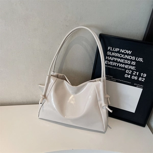 Chic cream-colored glossy tote bag with stylish drawstring knots and pleated details