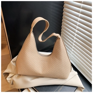 Détail du sac hobo tissé beige clair avec large bandoulière et fermeture éclair