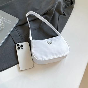 Detailed view of a white satin underarm bag featuring a silver butterfly metal ornament
