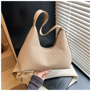Gros plan sur la texture tissée beige et l'artisanat du cuir d'un sac hobo rétro