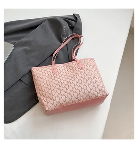 Top view of beige and pink letter pattern tote bag with metal rivet details and accessories