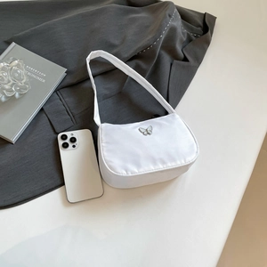 Close-up of a white shoulder bag featuring a silver butterfly clasp on nylon fabric