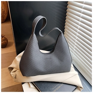Gros plan du sac hobo à texture tissée gris foncé dans un cadre lifestyle élégant