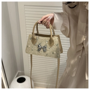 Lace woven straw bag featuring silver metallic bow and delicate floral embroidery detail