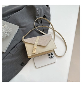 Detail view of beige crossbody bag with tweed flap, gold clasp and phone size comparison