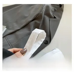 Detail of white nylon shoulder bag featuring reinforced stitched handle for durability