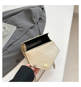 Detail view of cream crossbody bag interior with magnetic snap closure and gold hardware