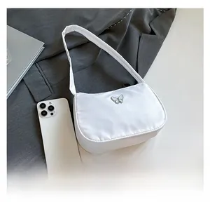 Detail view of white bow shoulder bag showing internal capacity with a smartphone