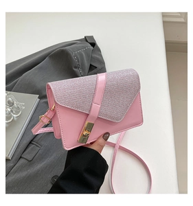 Detailed texture of pink crossbody bag with glitter fabric and gold twist lock