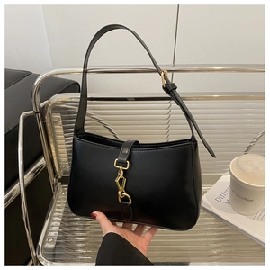 Detail of a black leather hobo bag featuring a golden piston lock and adjustable strap