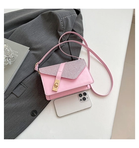 Pink leather crossbody bag with sequin flap detail and gold buckle beside a smartphone