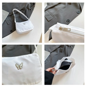 Detail view of white nylon underarm bag with silver butterfly and interior lining
