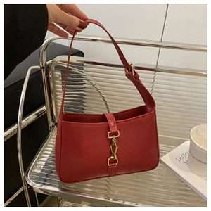 Detail of red crescent shoulder bag with golden metallic buckle and adjustable strap