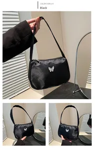 Detail of black nylon baguette bag featuring a stylish white butterfly decoration