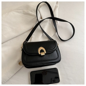 Draufsicht auf schwarze Satteltasche aus Leder mit goldener Schnalle und Smartphone-Maßstab
