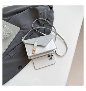 Detail of silver envelope crossbody bag with glitter texture and gold square lock