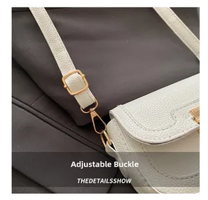Détail de la boucle dorée réglable et de la bandoulière en cuir blanc du sac à main