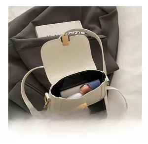 Vue intérieure d'un sac à bandoulière blanc montrant la capacité pour les cosmétiques