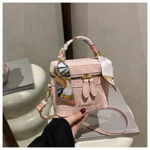 Detail of pink marble pattern handbag with fashion logo and silk scarf handle