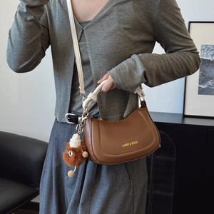French retro saddle bag in brown matte leather with elegant knot strap and plush pendant