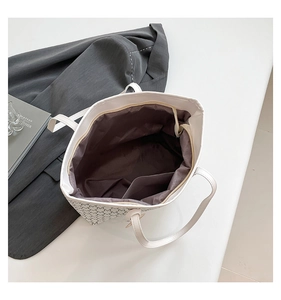 Macro view of spacious interior with internal pocket and repeat M pattern tote bag