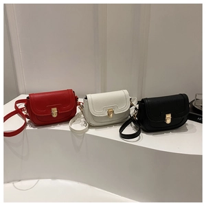 Trois sacs bandoulière en cuir rouge, blanc et noir avec fermoirs dorés sur support